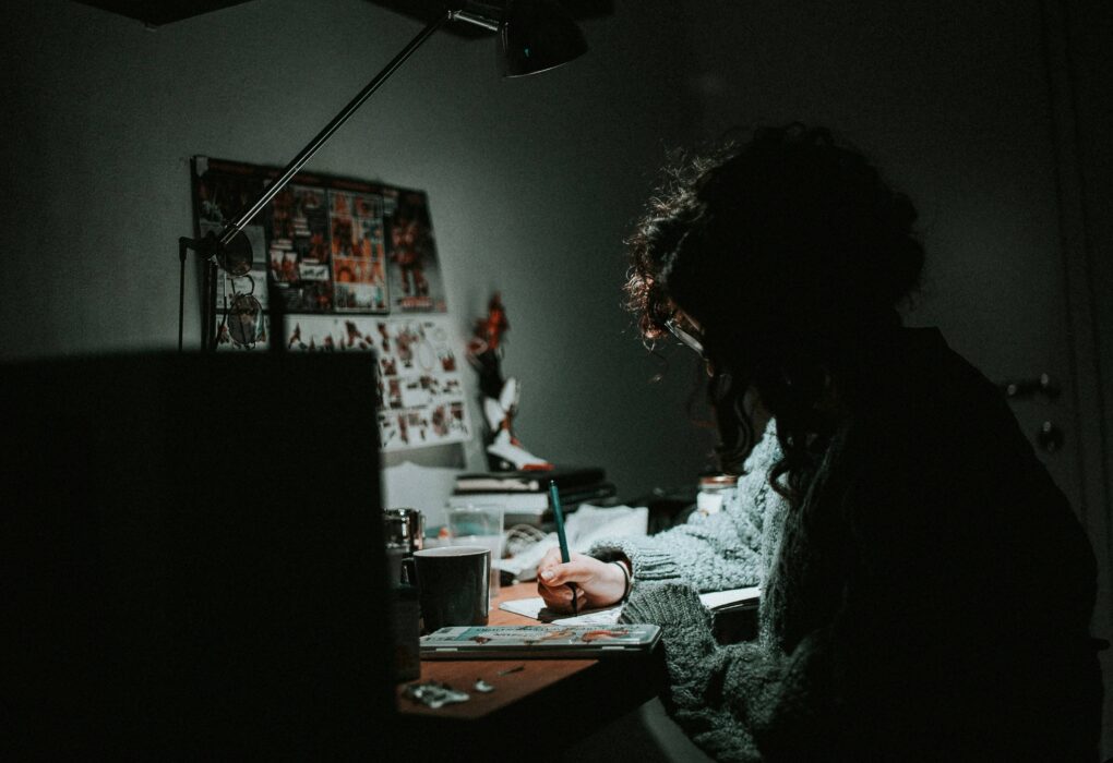 a person sitting at a desk writing on paper learning skills