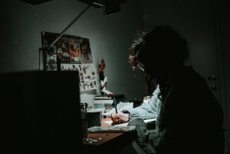 a person sitting at a desk writing on paper learning skills